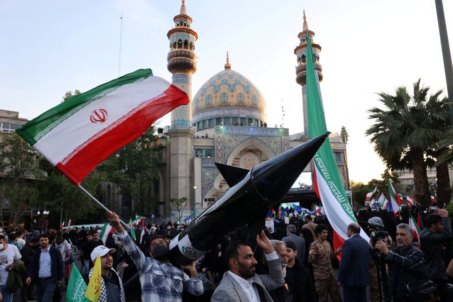 إيرانيون يحملون نموذجا لصاروخ في طهران خلال احتفال عقب الهجوم على إسرائيل (رويترز)
