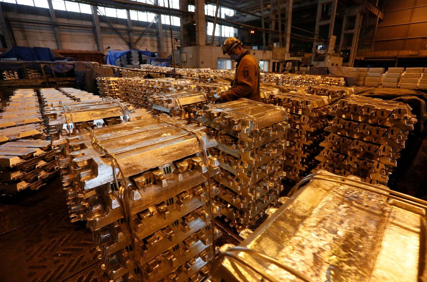 عامل يخزن سبائك الألومنيوم بمصنع صهر تابع لشركة «روسال كراسنويارسك» في روسيا (رويترز)