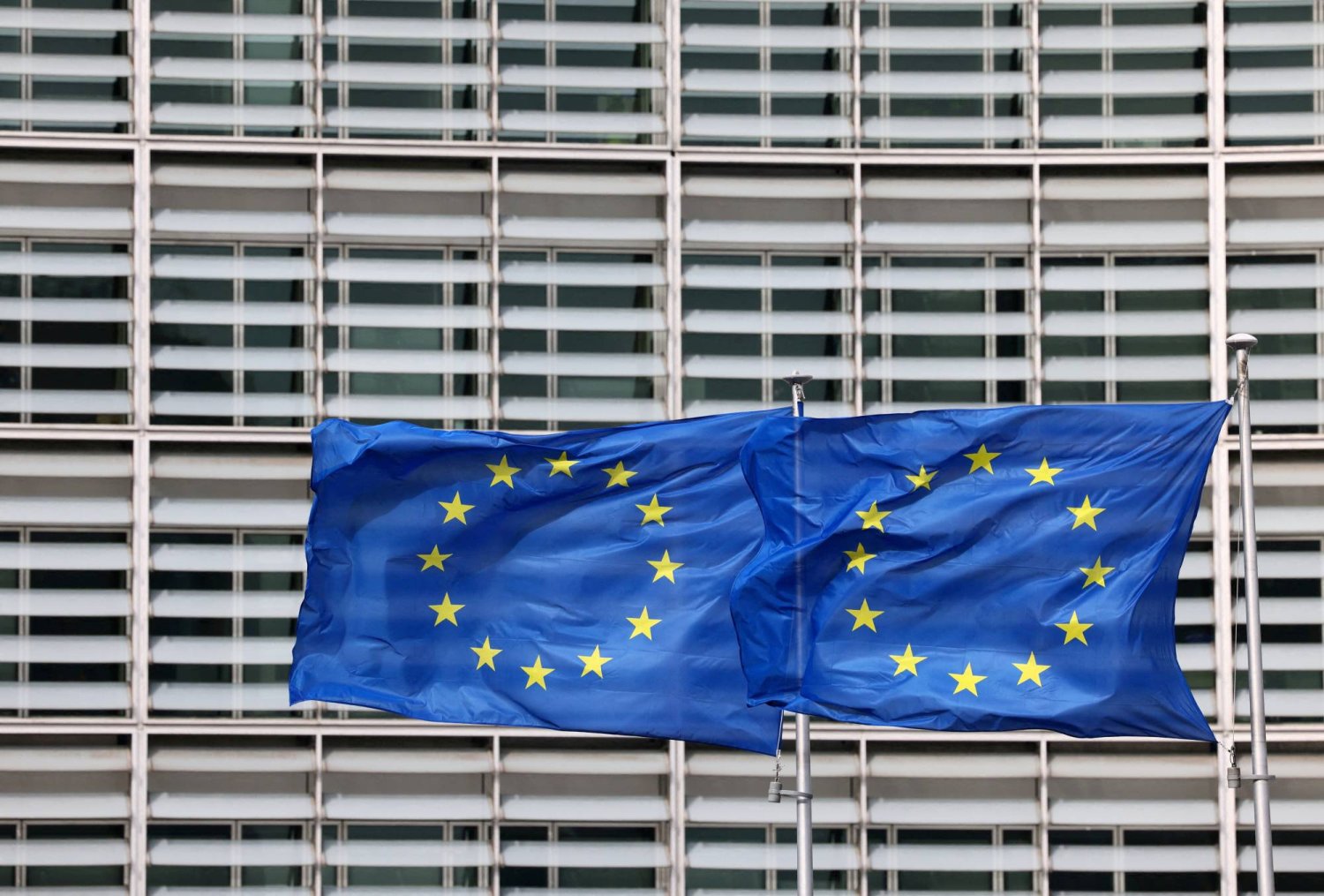 أعلام الاتحاد الأوروبي ترفرف خارج مقر مفوضية الاتحاد في بروكسل (رويترز)