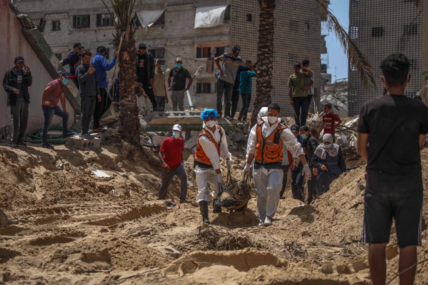 عاملون صحيون يستخرجون الجثث التي عثر عليها في مجمع ناصر الطبي بخان يونس جنوب غزة (أ.ف.ب)