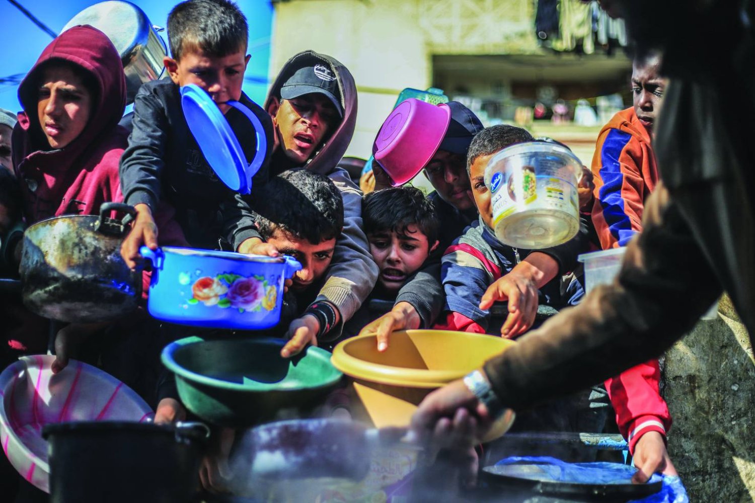 أطفال فلسطينيون يتلقون مساعدات غذائية في غزة في 31 ديسمبر 2023 (د.ب.أ)