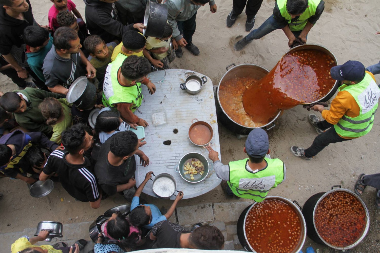 متطوعون يقدمون الطعام في مخيم جباليا شمال قطاع غزة (رويترز)