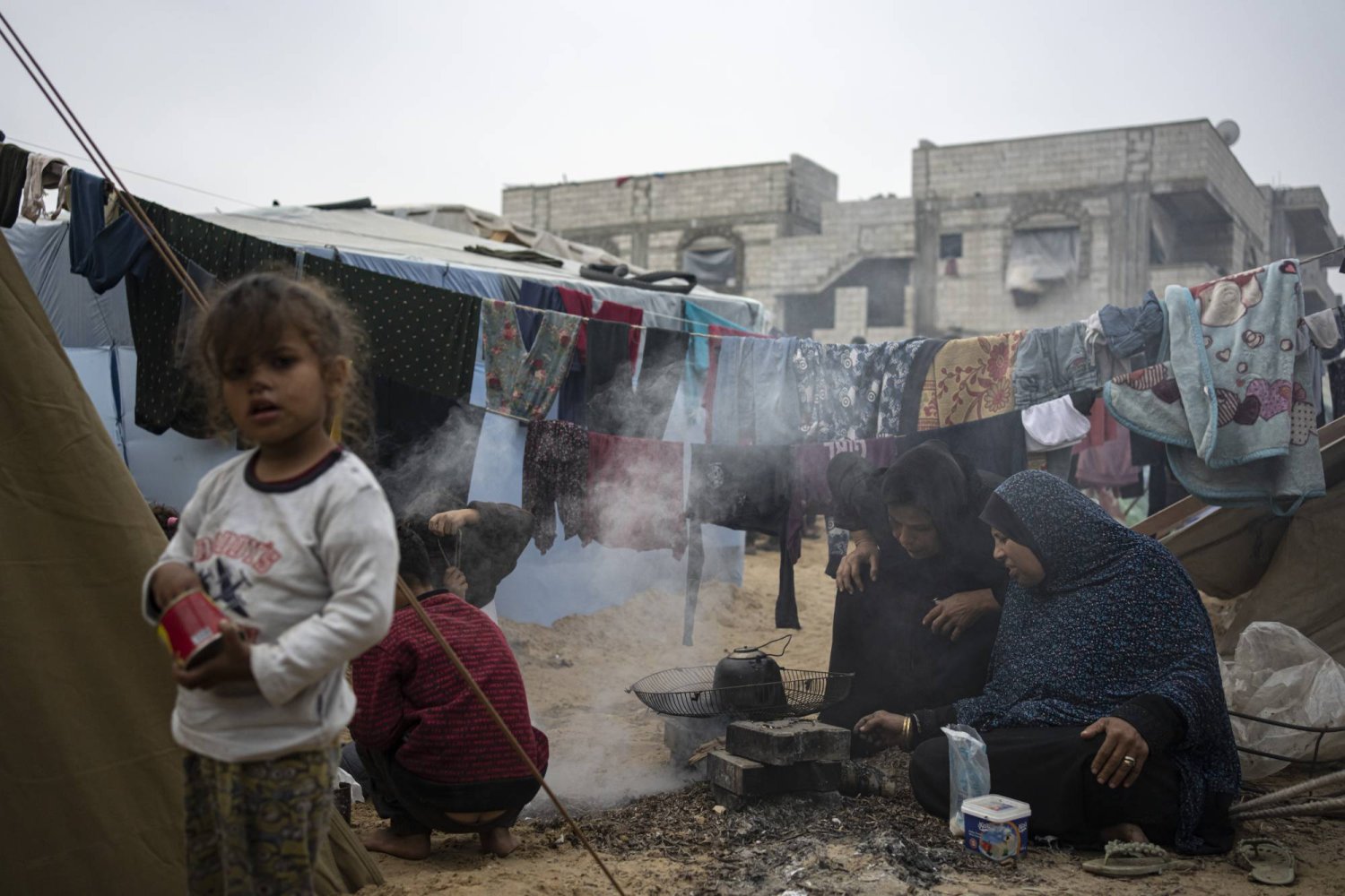 فلسطينيون نازحون بسبب القصف الإسرائيلي على قطاع غزة يطبخون في مخيم الخيام المؤقت بمنطقة المواصي (أ.ب)
