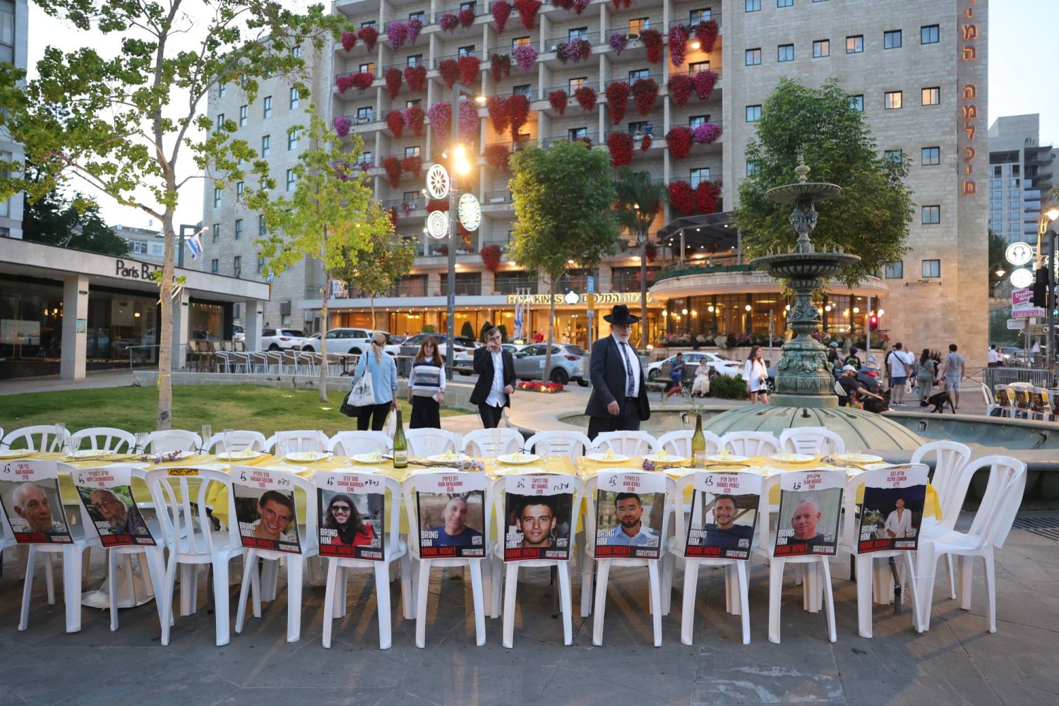 صور الرهائن الإسرائيليين موضوعة على كراسي مائدة عشاء عيد الفصح اليهودي خلال احتجاج خارج مقر إقامة رئيس الوزراء بنيامين نتنياهو 24 أبريل (إ.ب.أ)