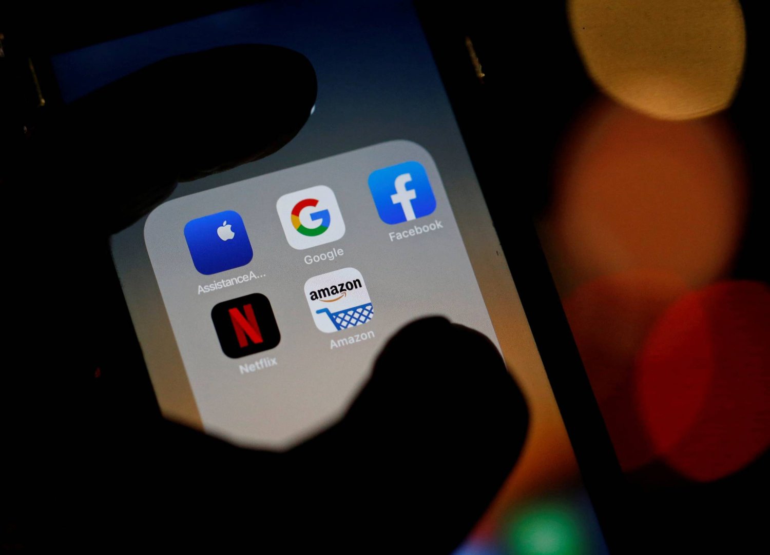 عرض شعارات تطبيقات الهاتف المحمول «غوغل» و«فيسبوك» و«أبل» و«نتفليكس» على الشاشة (رويترز)