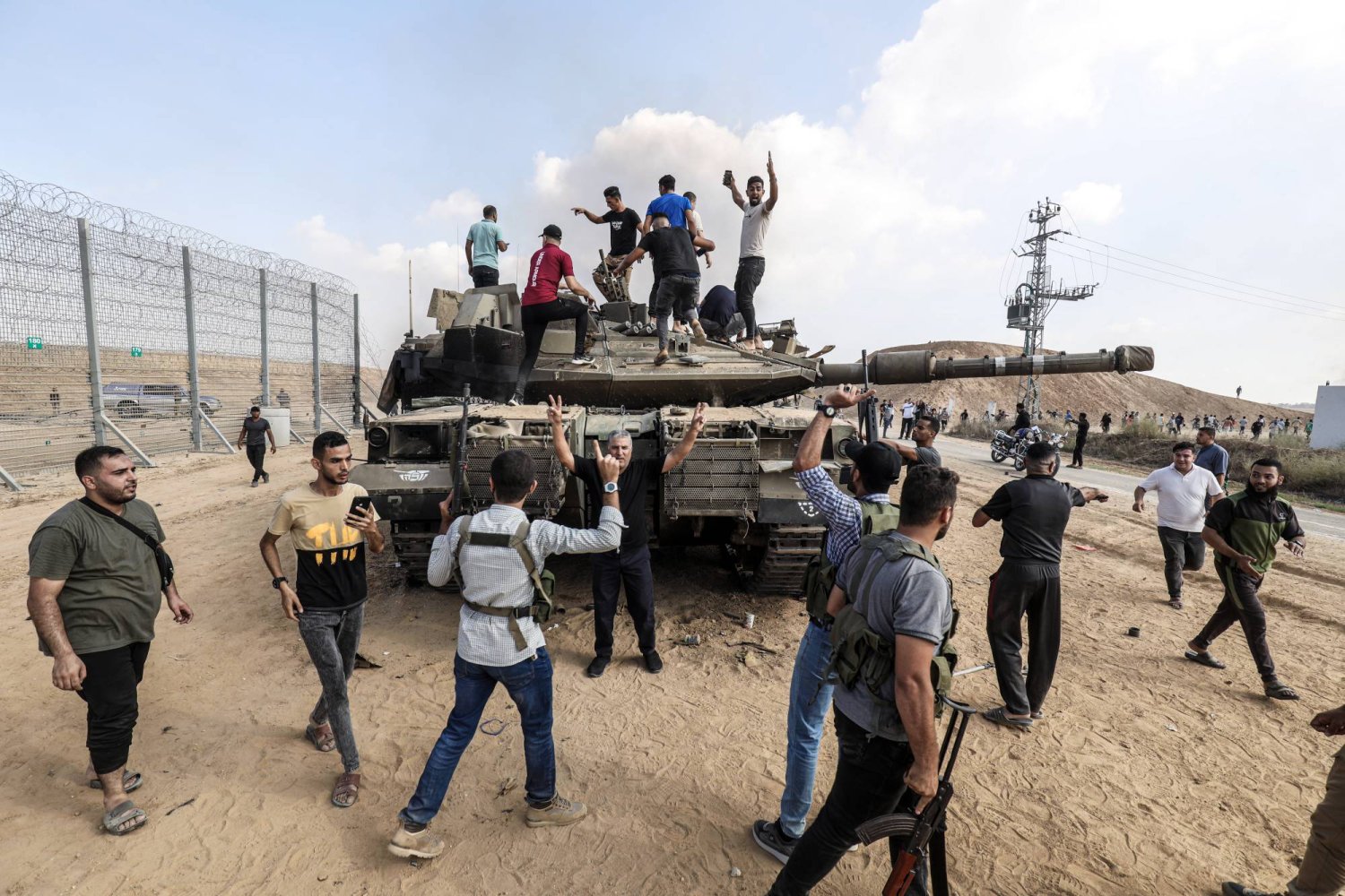 فلسطينيون فوق دبابة سيطر عليها مقاتلو «كتائب القسام» قرب خان يونس يوم 7 أكتوبر (د.ب.أ)