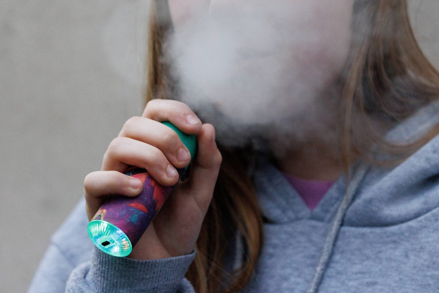 فتاة تستخدم أحد منتجات التدخين الإلكتروني في لندن (إ.ب.أ)