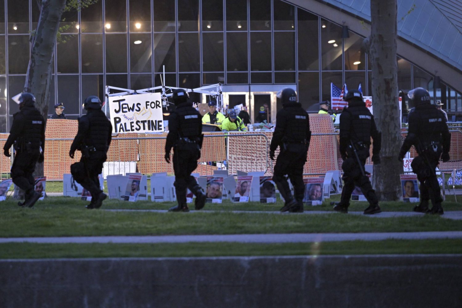 A line of police in riot gear walk past police dismantling pro-Palestinian encampment at MIT, before dawn Friday, May 10, 2024, in Cambridge, Mass. (AP Photo/Josh Reynolds)
