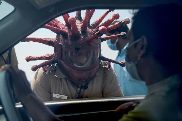 police_inspector_rajesh_babu_c_wearing_coronavirus-themed_helmet_speaks_to_a_motorist_during_a_government-imposed_nationwide_lockdown_against_covid-19_in_chennai_on_march_28_2020._afp_0.jpg